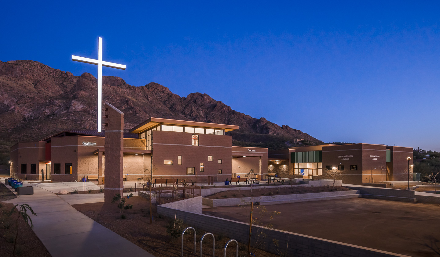 exterior of church lit up at night with mountain in background