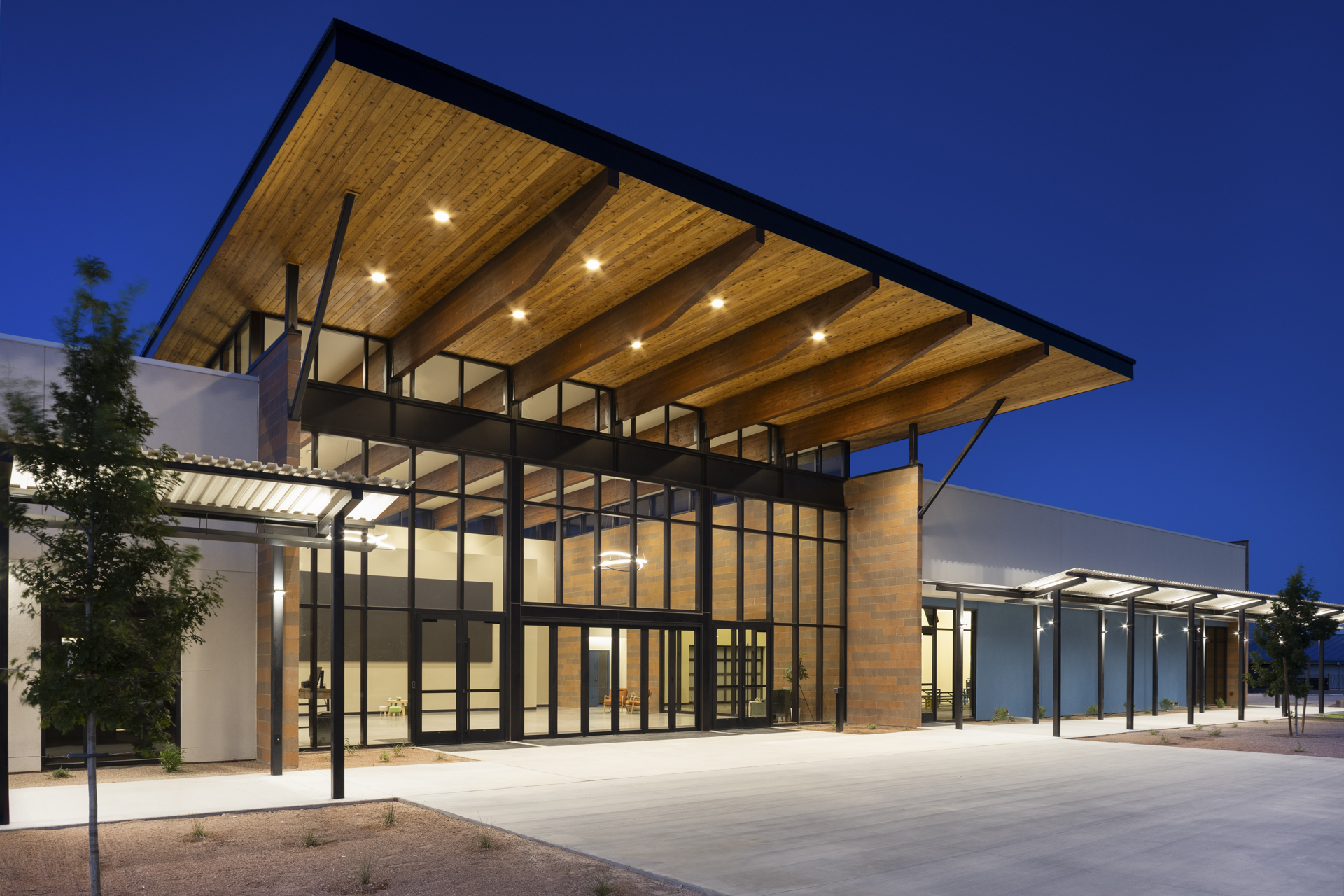 External view of building with sloped roof and lights.