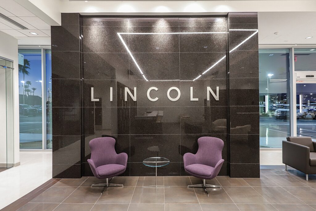 Purple chairs in waiting area with 'Lincoln' branding on wall