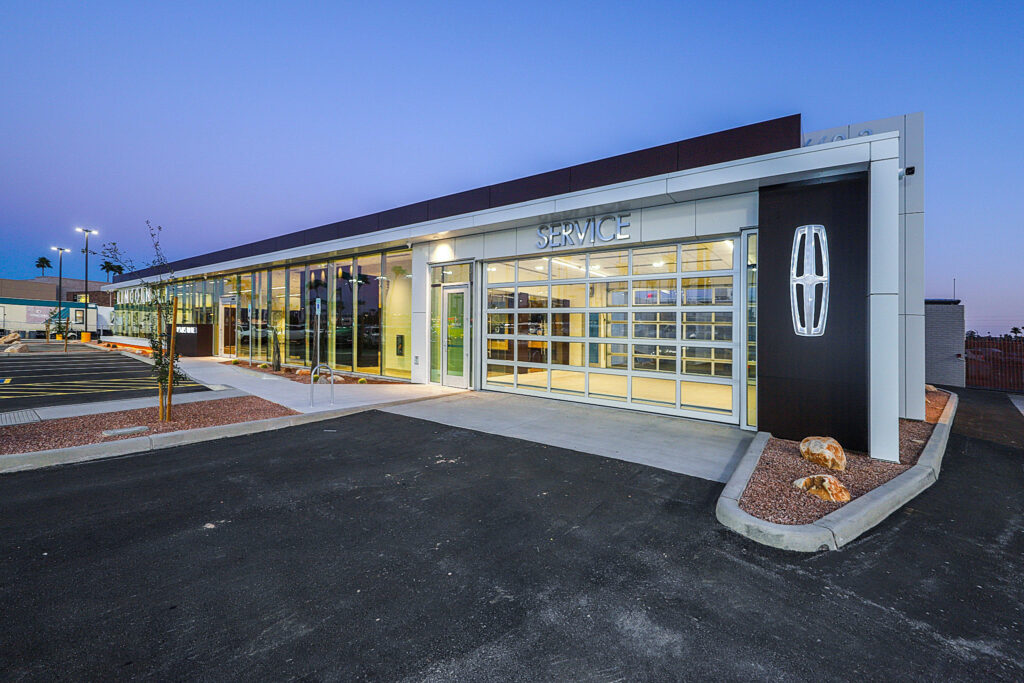 Exterior of car dealership with window paneled wall and Lincoln branded sign