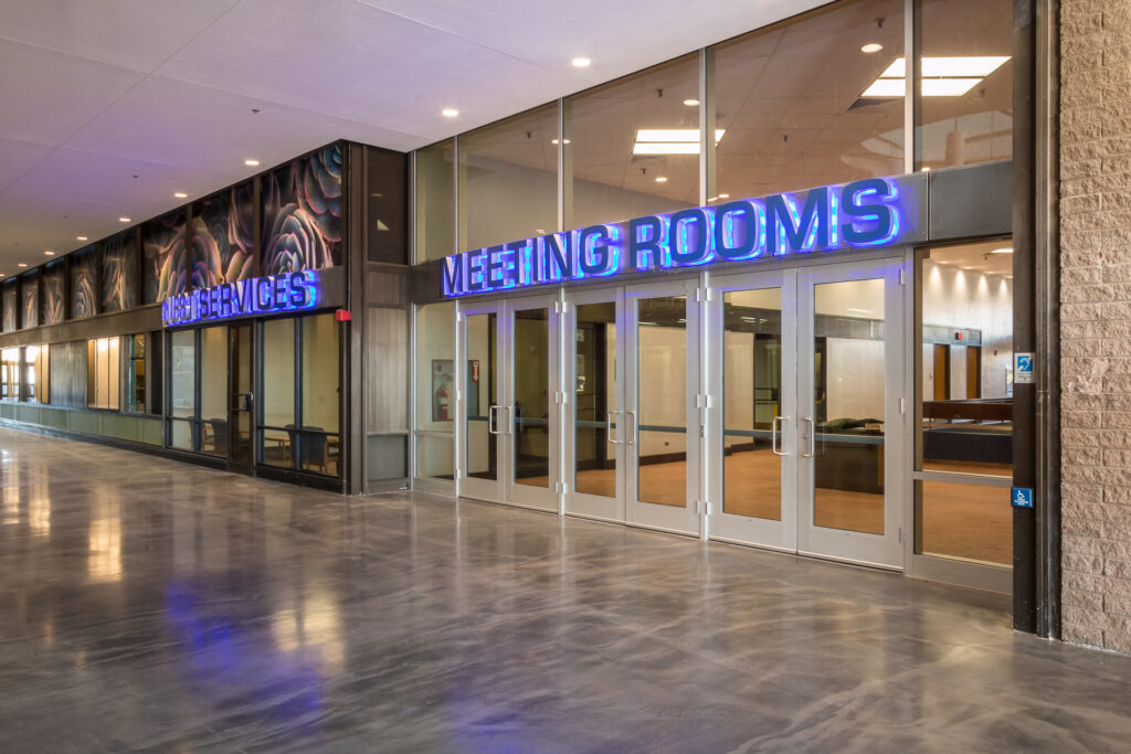 Hallway in large event center and 'restroom' sign in blue