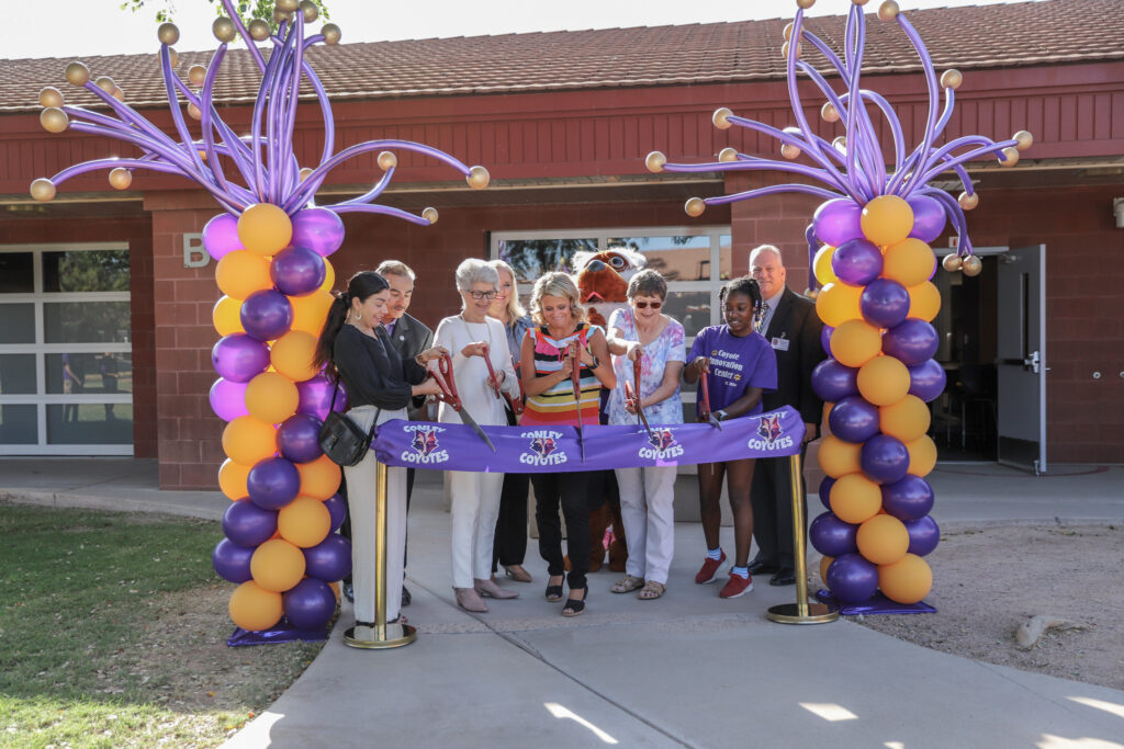 Conley Elementary School representatives cutting a ribbon between balloon pillars