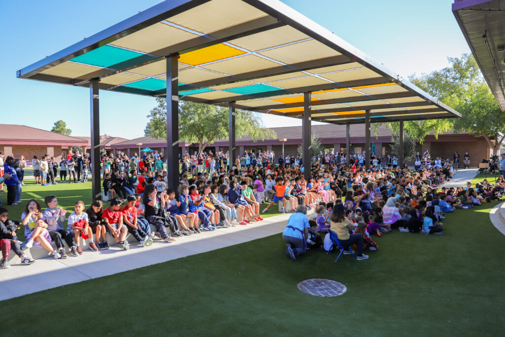 Sanborn students, staff, and family cheering under a new awning