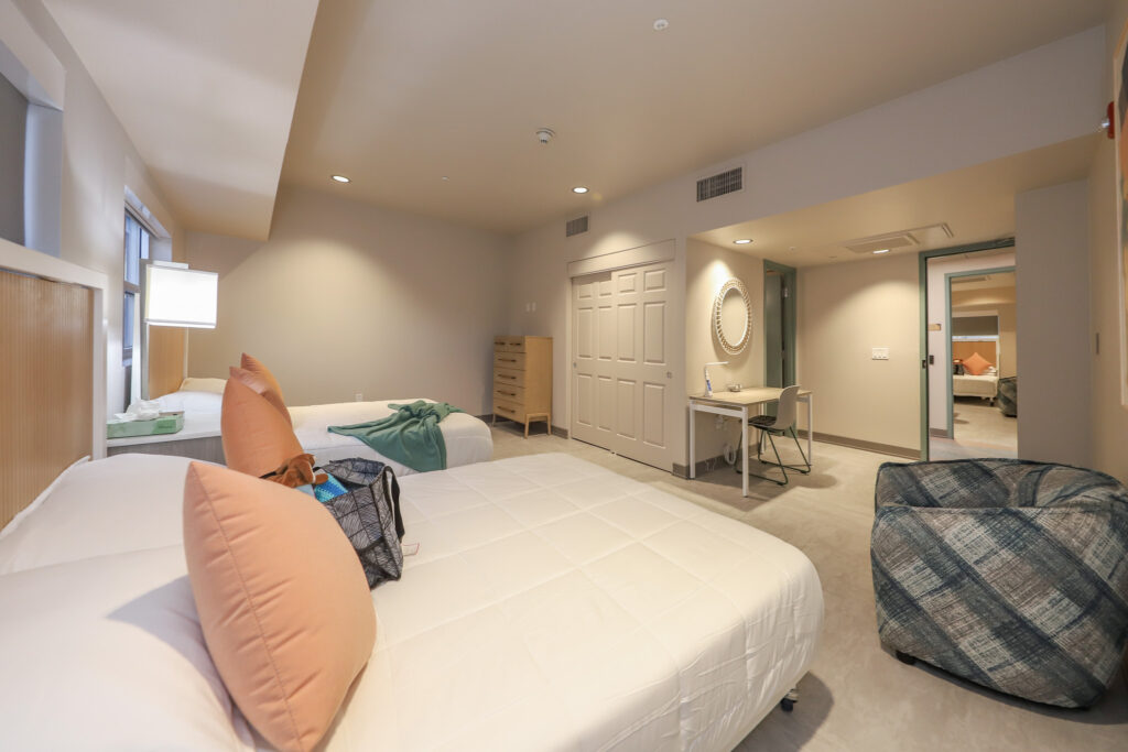 Interior of bedroom with two beds and loveseat
