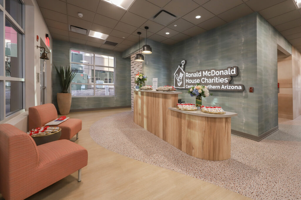 interior front check in desk with two red chairs.
