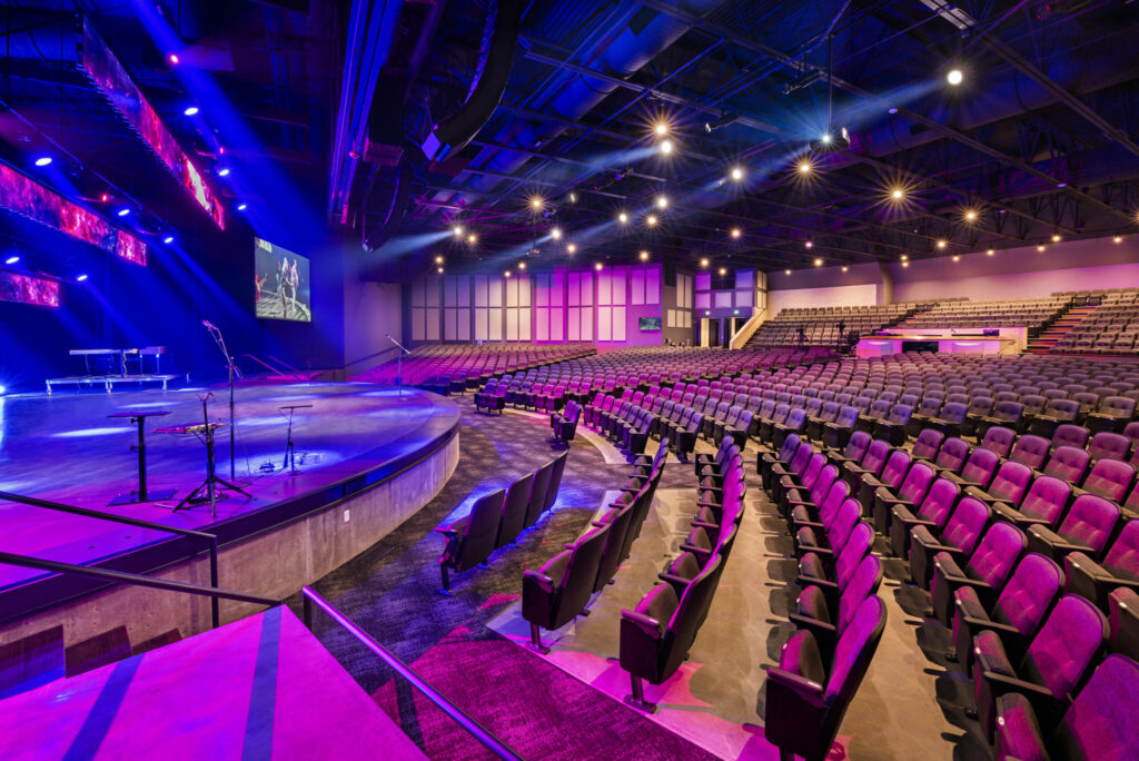 Interior of worship center seating with blue and pink lights