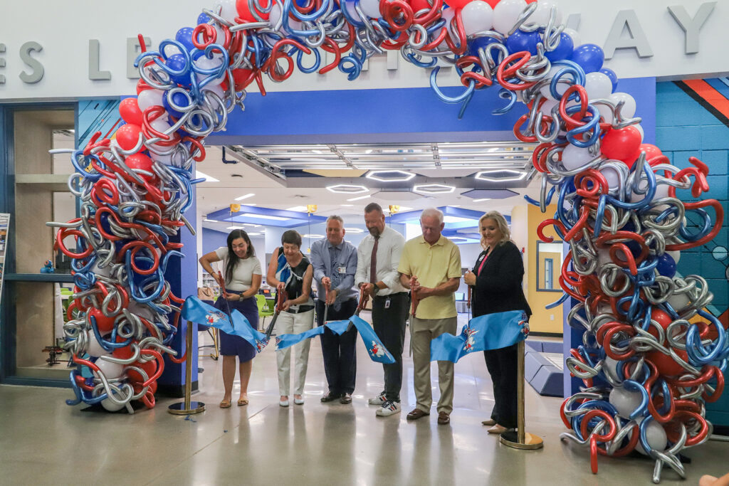 CUSD representatives cut a ribbon with the Hull logo under a balloon arch